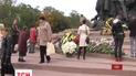 Люди впродовж цілого дня люди несуть квіти до пам'ятника жертва розстрілів