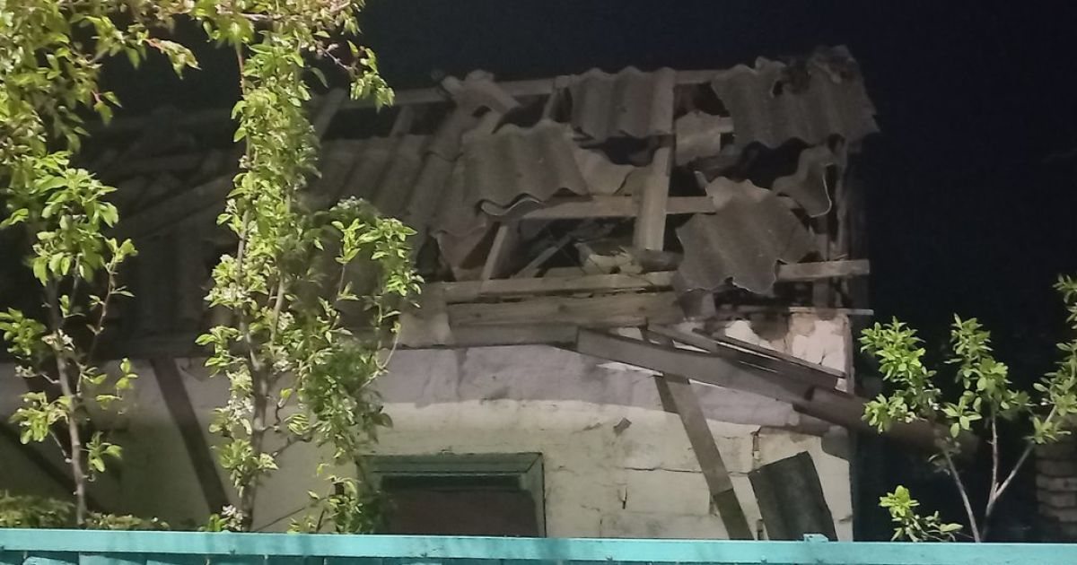 Люди прибирають уламки, прибирають вибите скло після ракетного удару