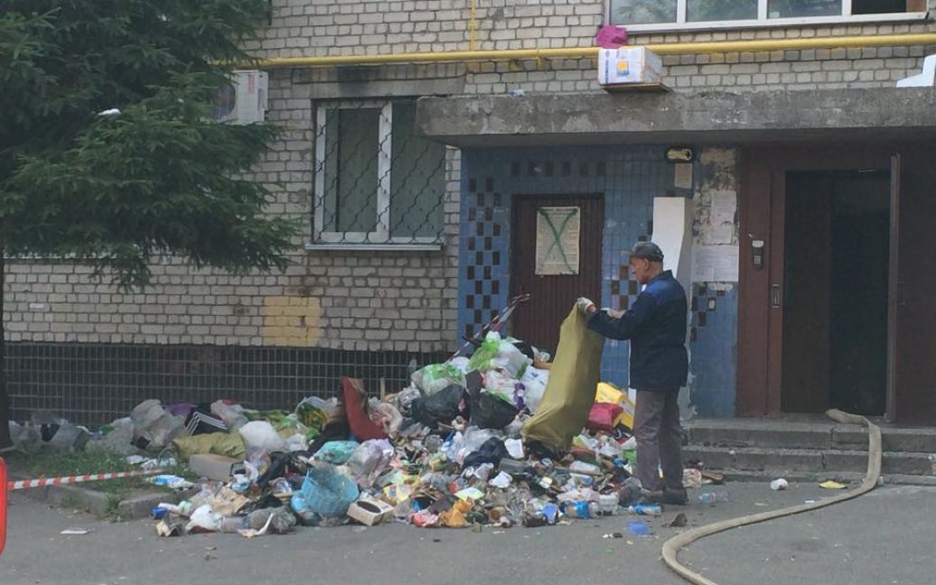 Пожарные выбрасывают из квартиры мусор, чтобы добраться до очага пожара / © Фото Валерии Ковалинской/ТСН