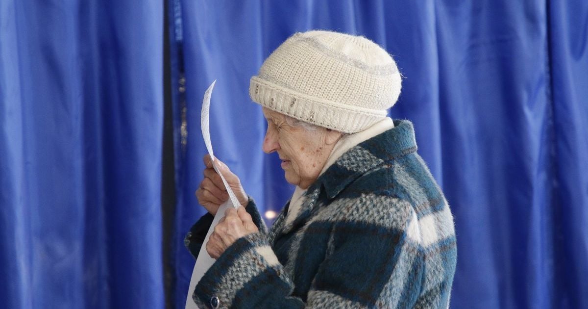 Голова комісії на одній з дільниць Миколаєва підсвічує виборцям ліхтариком у кабінці