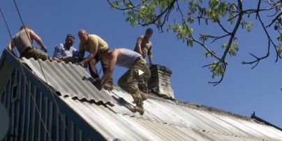 Ветераны АТО отметили праздник трудящихся, латая разбитый снарядом дом на Донбассе