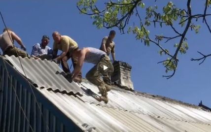 Ветераны АТО отметили праздник трудящихся, латая разбитый снарядом дом на Донбассе