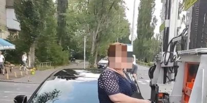 Сіла на авто та перешкоджала евакуатору: у Києві жінка курйозно захищала водія-порушника