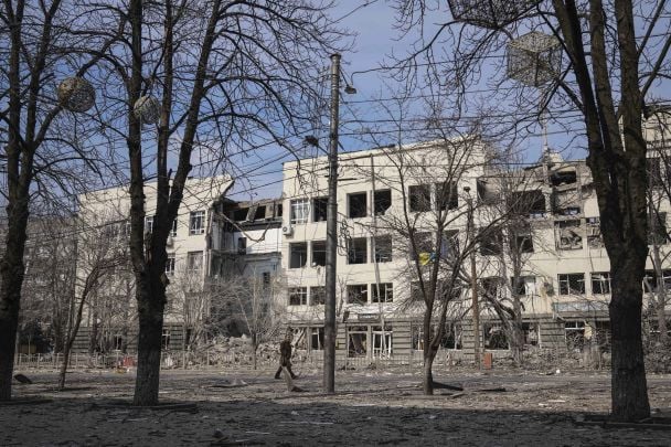 A man walks past a building that was damaged by shelling in Mira Avenue / © Associated Press