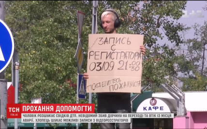 Киевлянин с плакатом возле дороги разыскивает видео с регистратора, которое помогло бы найти виновника ДТП