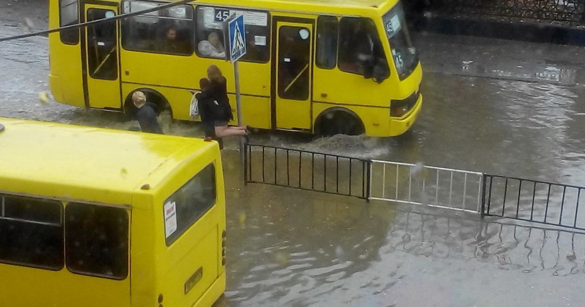 Полицейские переносят пассажиров маршруток через затопленную дорогу / © Вконтакте/lviv_go