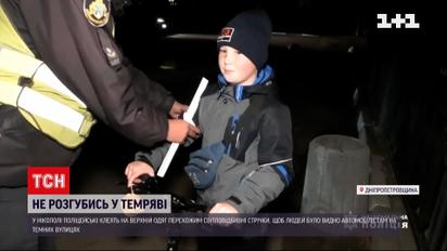"Не розгубись у темряві": у Нікополі поліцейські клеять перехожим світловідбивні стрічки