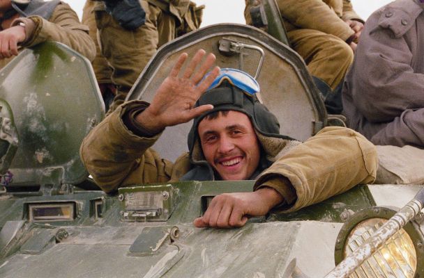 Радянський солдат усміхається, коли його броньований конвой повертається до СРСР вздовж північного шосе Афганістану, 7 лютого 1989 року / © Associated Press
