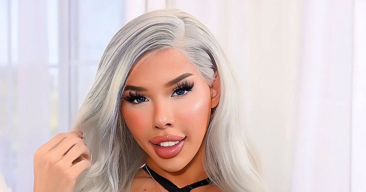 Бір қыз жұмсақ ойыншыққа мысығын ысқылайды