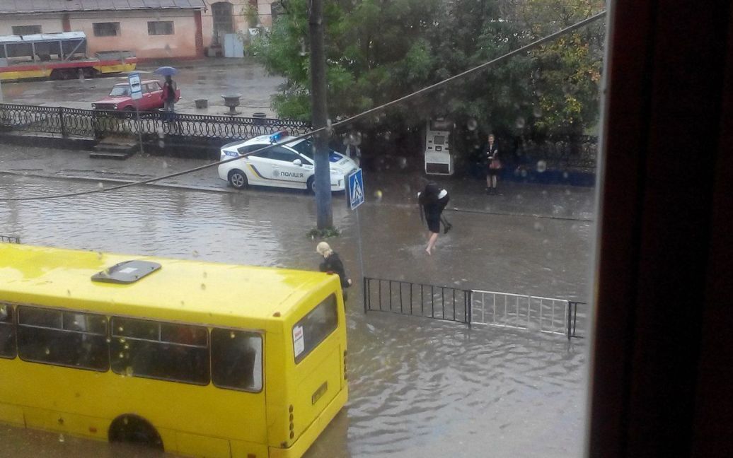 Полицейские переносят пассажиров маршруток через затопленную дорогу / © Вконтакте/lviv_go