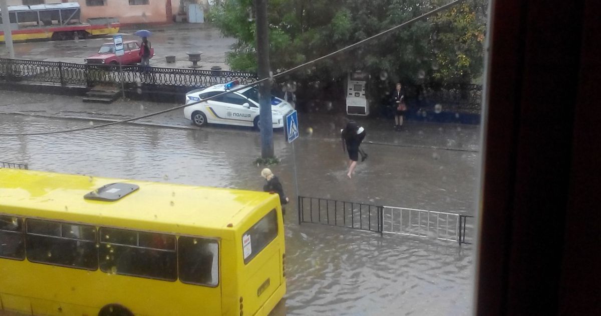 Полицейские переносят пассажиров маршруток через затопленную дорогу / © Вконтакте/lviv_go