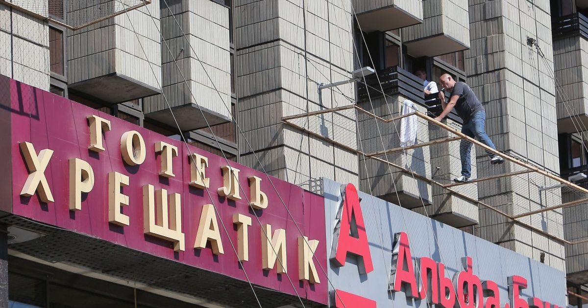 Охранник уговаривает неизвестного вернуться к зданию / © УНИАН