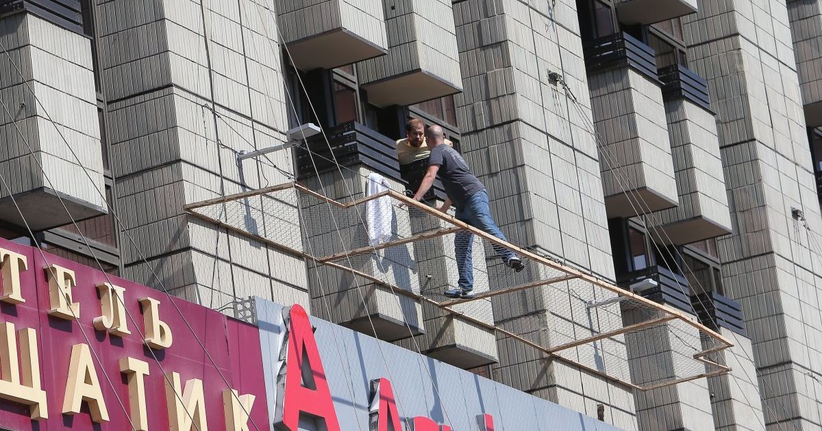 Охранник уговаривает неизвестного вернуться к зданию / © УНИАН