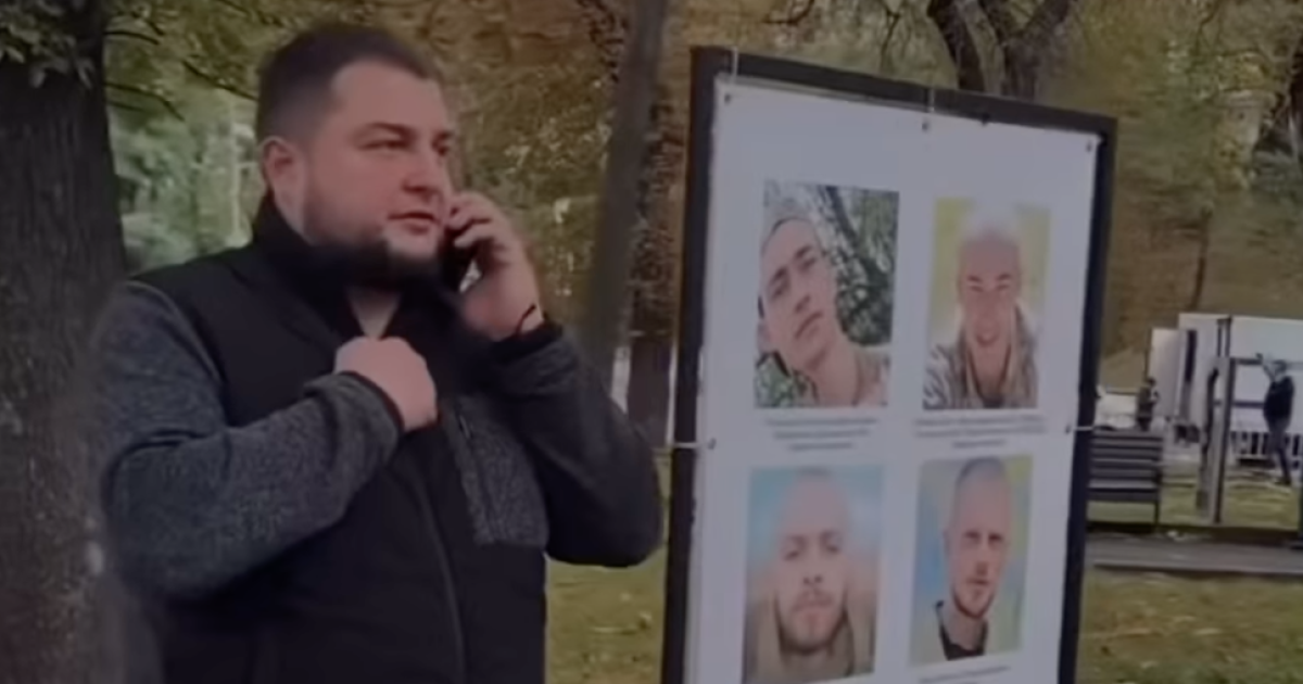 Юрий Холод на фоне плакатов с военными, пропавшими без вести или попавших в плен/Фото: скриншот