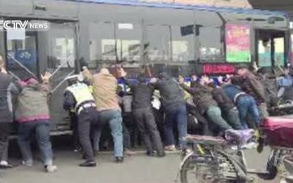 У Китаї заради порятунку чоловіка люди підняли автобус