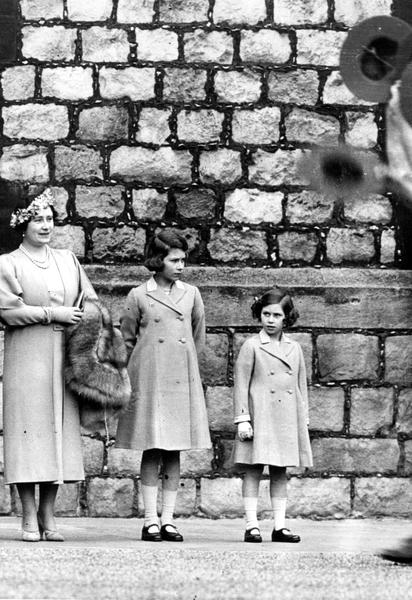 Будущие король и королева, Георг, герцог Йоркский и Елизавета, герцогиня Йоркская со своими дочерьми, принцессами Елизаветой и Маргарет в 1932 году смотрят парад бойскаутов в Виндзорском замке, Беркшир. / © Getty Images