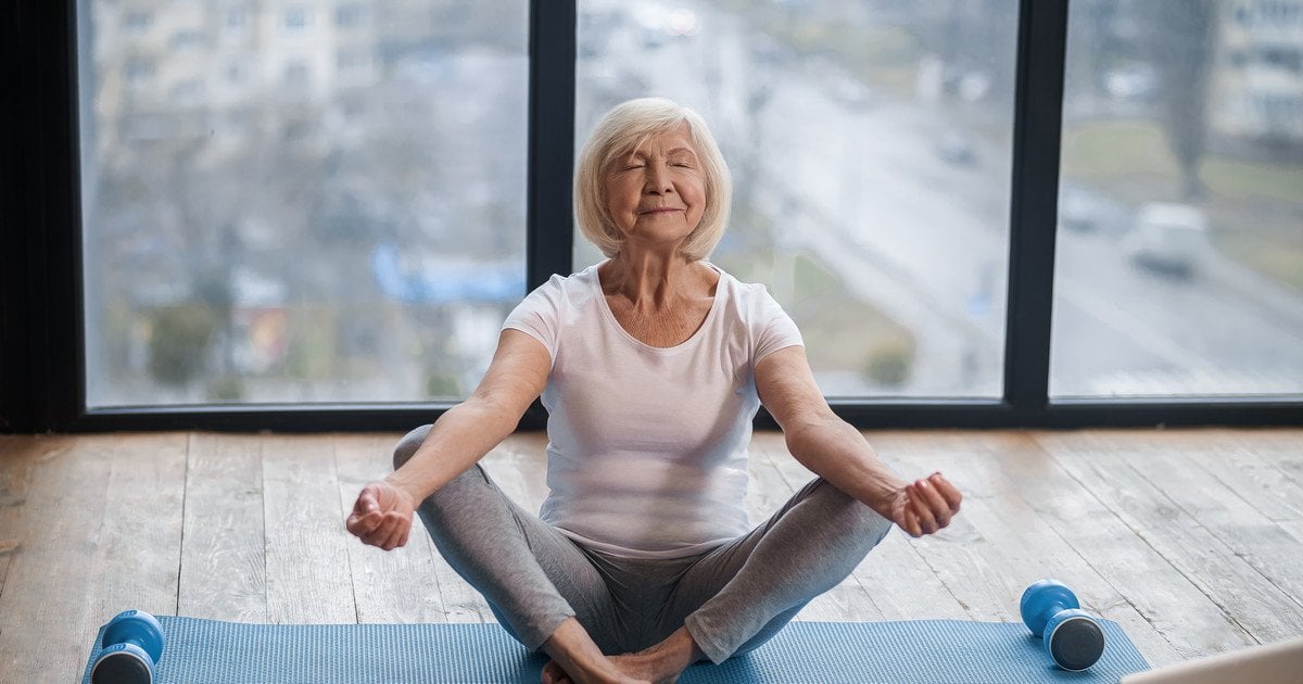 Літня жінка займається йогою