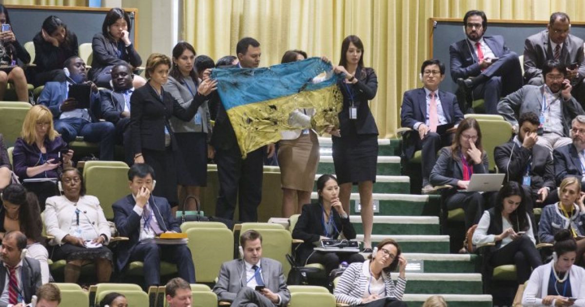 Члены украинской делегации развернули расстрелянный государственный флаг с Иловайска во время выступления президента России Владимира Путина на открытии 70-й сессии Генеральной Ассамблеи ООН в Нью-Йорке. / © УНИАН