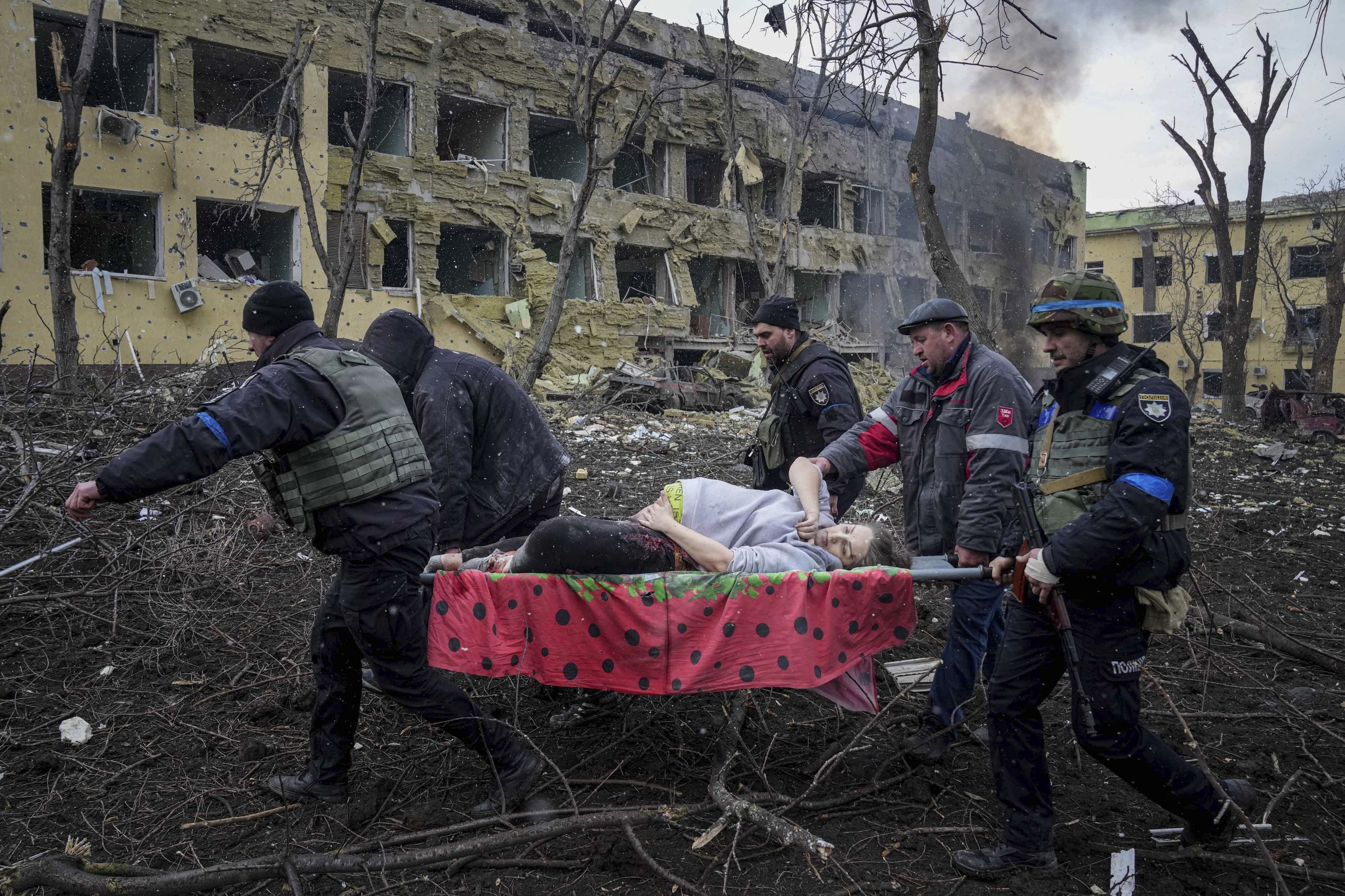 Ukrainian emergency employees and volunteers carry an injured pregnant woman from a maternity hospital that was damaged by shelling / © Associated Press