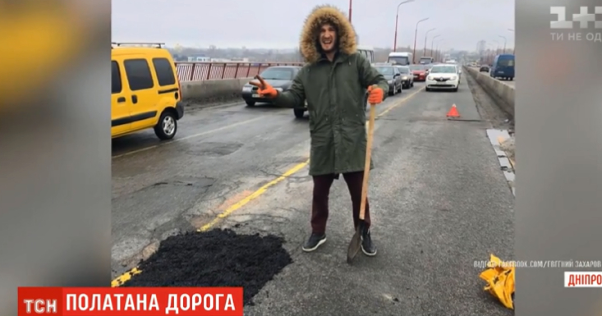 Пробитые колеса заставили водителей самостоятельно латать ямы на мосту в Днепре