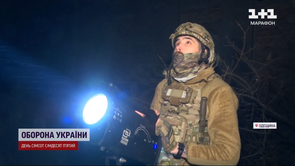 Воїн ЗСУ наводить прожектор на дрони