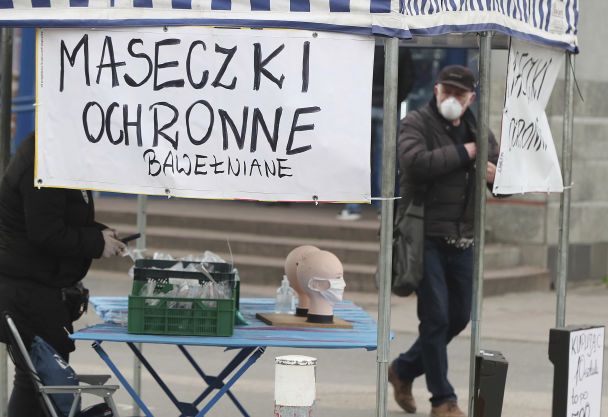 Борясь с нехваткой защитных масок от распространения коронавирус, частная фирма продает хлопковые маски на улице в Варшаве.
