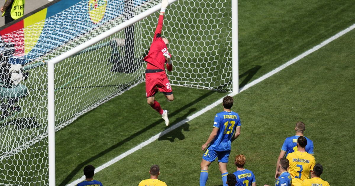 Голкіпер збірної України Андрій Лунін стрибає за м'ячем під час матчу з Румунією