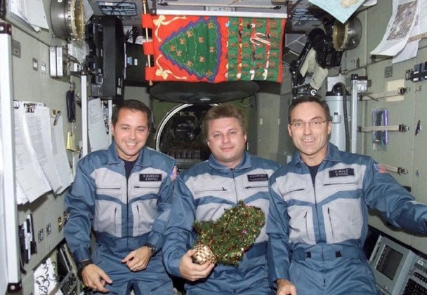 Експедиція 4 (2002 рік): колишні астронавти NASA Даніель Берш та Карл Вальц разом із космонавтом Роскосмосу Юрієм Онифрієнком позують із святковою атрибутикою. / © popsci.com