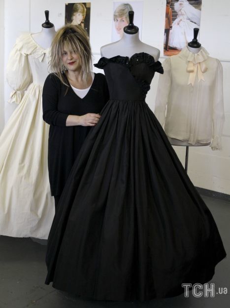 Дизайнер Элизабет Эмануэль стоит с двумя платьями и блузкой, которые она спроектировала для принцессы Дианы на аукционе в Лондоне. / © Associated Press