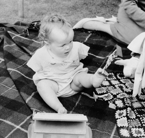Маленький Томас Йенделл поднимает игрушки ногами. Лондон, 1 августа 1963 года / © Associated Press