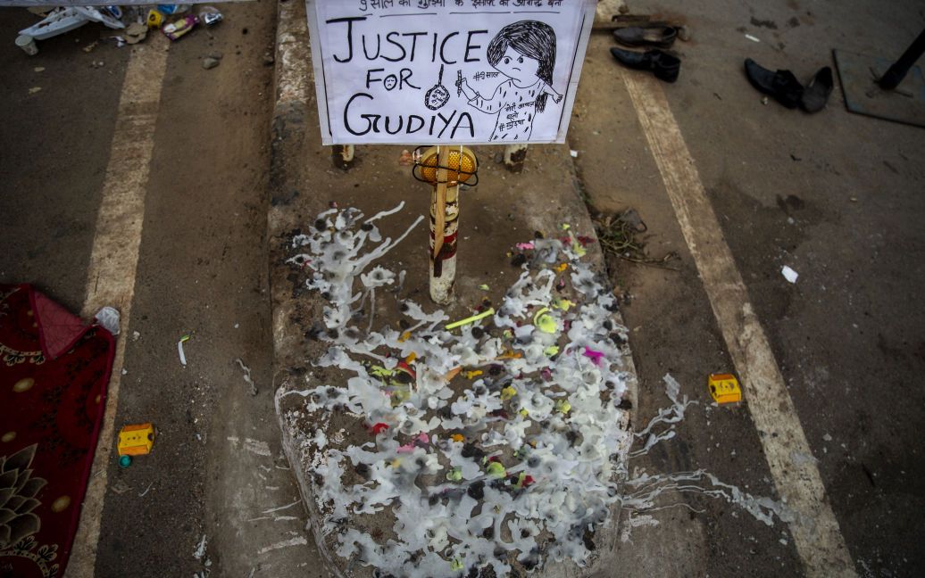 Расплавленные свечи возле таблички на демонстрационной площадке у крематория, где 9-летняя девушка из низшей касты Индии была изнасилована и убита / © Associated Press