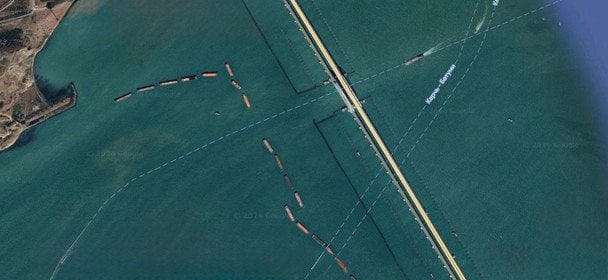 Супутниковий знімок району Кримського мосту, на якому видно баржі та захисні споруди навколо переправи.  / © Google Maps