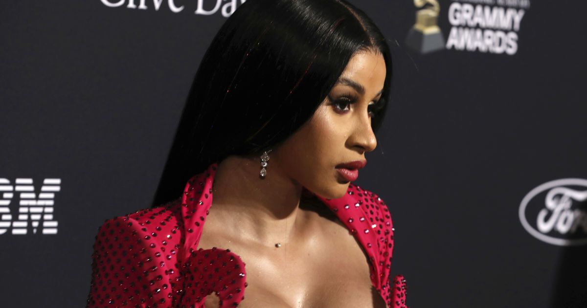 Білявка Cardi B у вбранні з надглибоким декольте еротично облизала пістолет