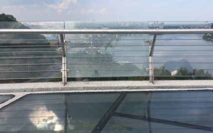 На пешеходном мосту Киева снова треснуло стекло