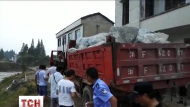 Десяток грузовиков с камнями сбросили в реку, чтобы заблокировать дамбу в Китае