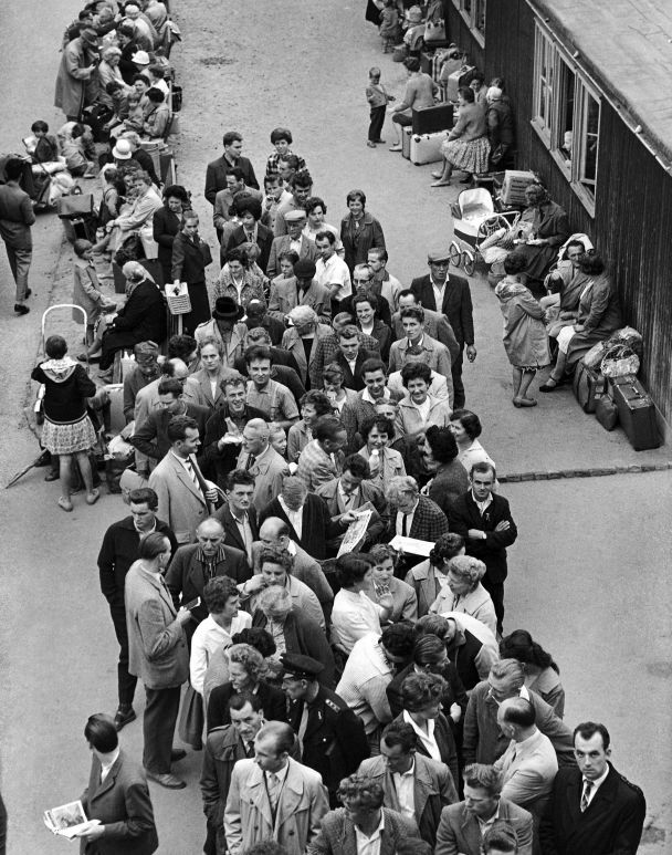 Біженці з комуністичної Східної Німеччини, більшість з яких молоді люди, чекають своєї черги, щоб пройти реєстраційні формальності після прибуття до табору прийому Марієнфельде у Західному Берліні, Німеччина, 2 серпня 1961 року. / © Associated Press