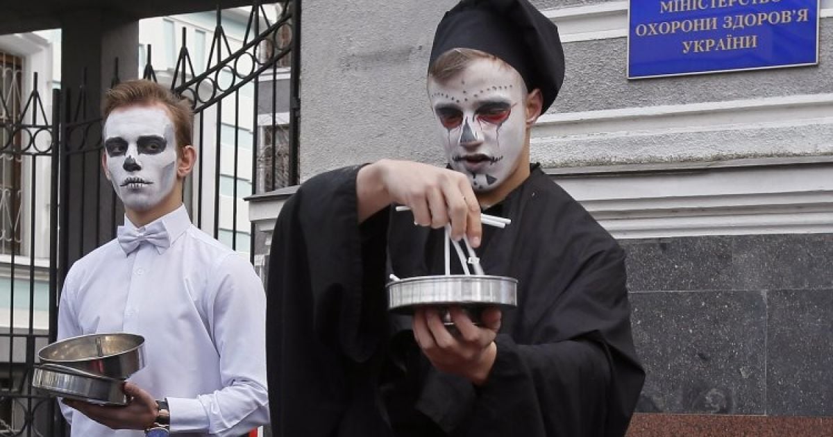 Учасники флешмобу, "тютюновий кондитер" та фокусник у костюмі смерті, готує "тютюнові десерти", які роблять смертельний продукт "смачнішим" і приваблюють дітей спробувати сигарети вперше, під час акції з нагоди Міжнародного дня відмови від куріння у Києві. Активісти вимагають заборонити виготовлення ароматизованих сигарет, як це планують зробити у всіх країнах ЄС у травні 2016 року. Сигарети зі смаками ванілі, яблука, полуниці, шоколаду та іншими ароматизаторами складають значну частину асортименту й призначені переважно для підлітків, молоді та жінок. / © УНІАН