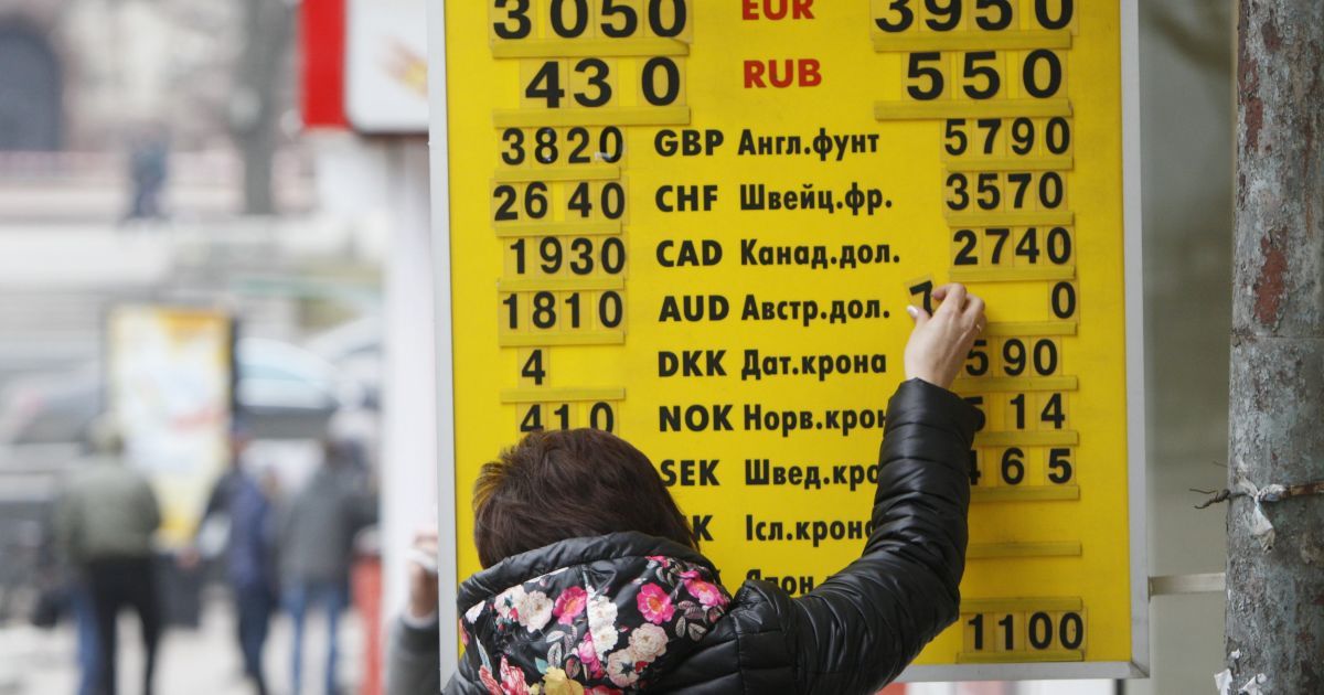 Работница банка 26 февраля меняет цифры на табло курсов валют