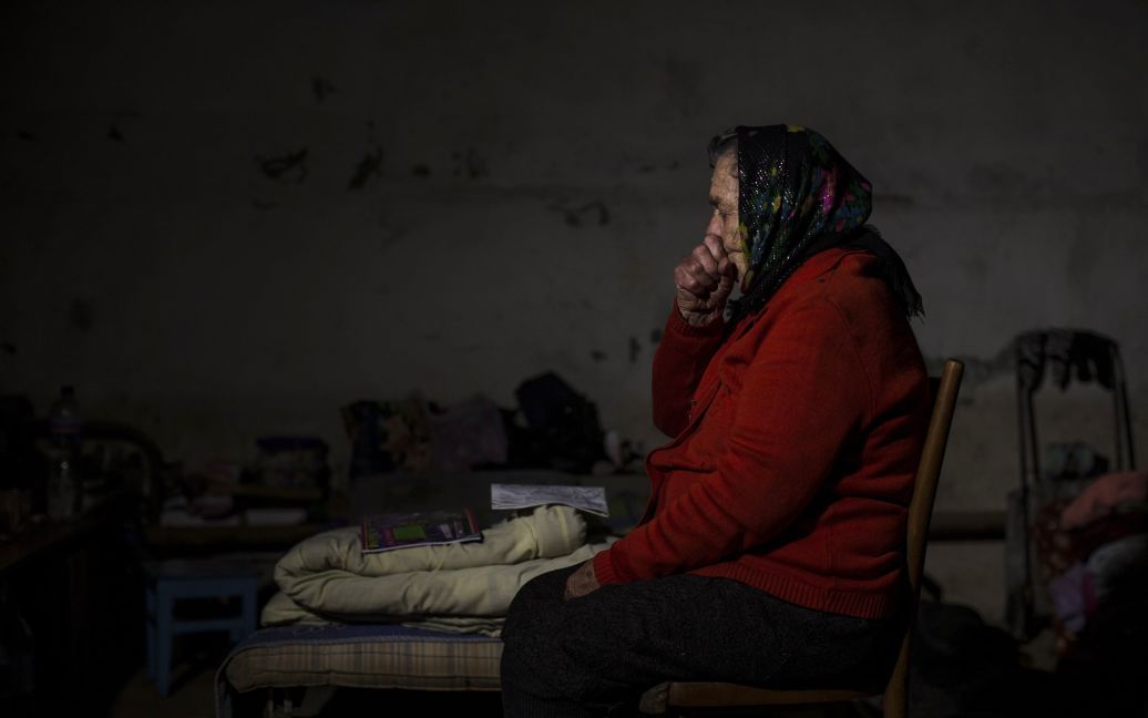 Женщина сидит в подвале, который использовали как бомбоубежище во время обстрелов / © Reuters