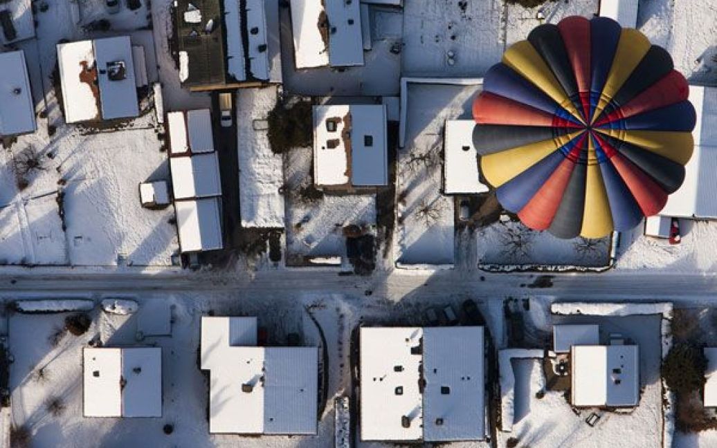 Фото Валентина Флоро. Швейцарія, Chateau-d&rsquo;Oex. Повітряна куля пропливає над швейцарським замком Chateau-d&rsquo;Oex під час Міжнародного тижня повітряних куль-монгольф&rsquo;єрів, який проводять кожного січня з 1979 року. / © Reuters