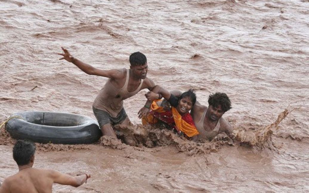 Фото Аджая Верма. Північна Індія, Панчкула. Повінь на річці Гагар. Жінки застрягли у воді, і рятувальна команда готується їх врятувати. / © Reuters