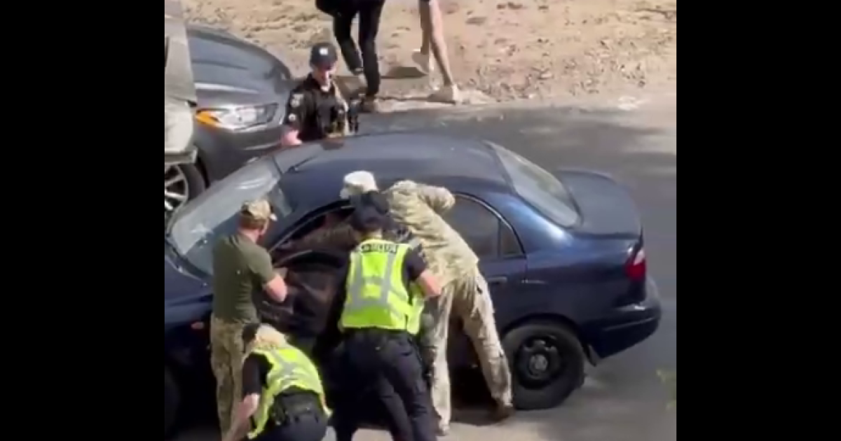 Скриншот з відео, де поліція і ТЦК силоміць дістає водія з автівки