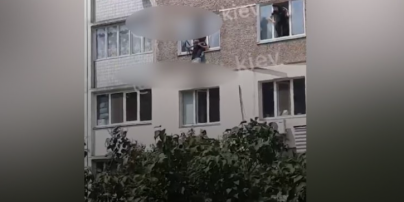Висіла догори ногами: у Києві жінка намагалася вистрибнути з вікна (відео)