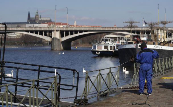 Работник дезинфицирует забор возле реки Влтава, чтобы предотвратить распространение нового коронавирус в Праге / © Associated Press
