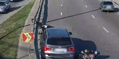 В Киеве мужчина на мотоцикле упал под колеса, когда его буксировал Mercedes: видео