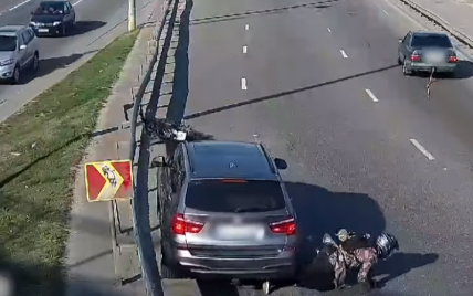 В Киеве мужчина на мотоцикле упал под колеса, когда его буксировал Mercedes: видео