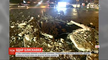 В США молния попала в автозаправку и образовала на асфальте провал