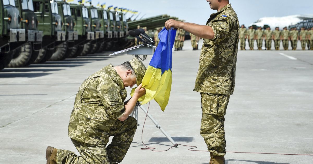 Президент Украины Петр Порошенко стал на колено перед флагом Украины. 22 августа глава государства находился с рабочим визитом в Харьковской области. В ходе визита Порошенко выступил перед личным составом подразделений Вооруженных Сил Украины и передал им 170 единиц военной техники. / © УНИАН