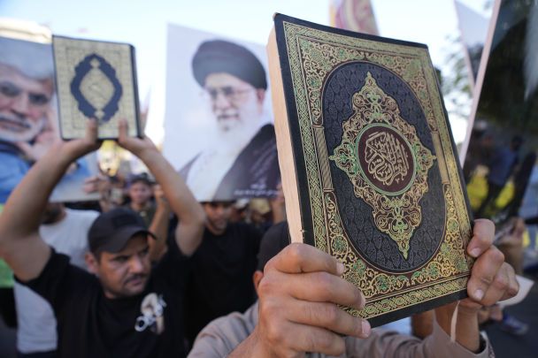 Иракцы поднимают копии Корана, священной книги мусульман, во время акции протеста в Багдаде, Ирак, 22 июля 2023 года/AP