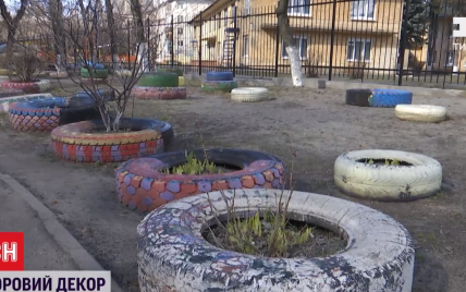 Конец декора советской эпохи: в Киеве вывозят резиновые шины из дворов многоэтажек